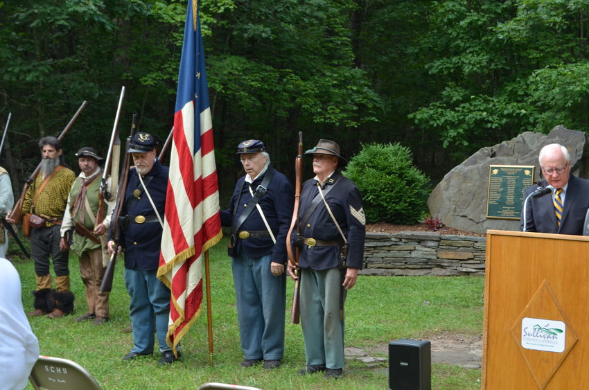Members of the Navasing Long Rifles, the 5th NY Infantry, and the 143rd NYS Volunteer Infantry, left, stand with Sullivan County Historian John Conway for the presentation of the colors.